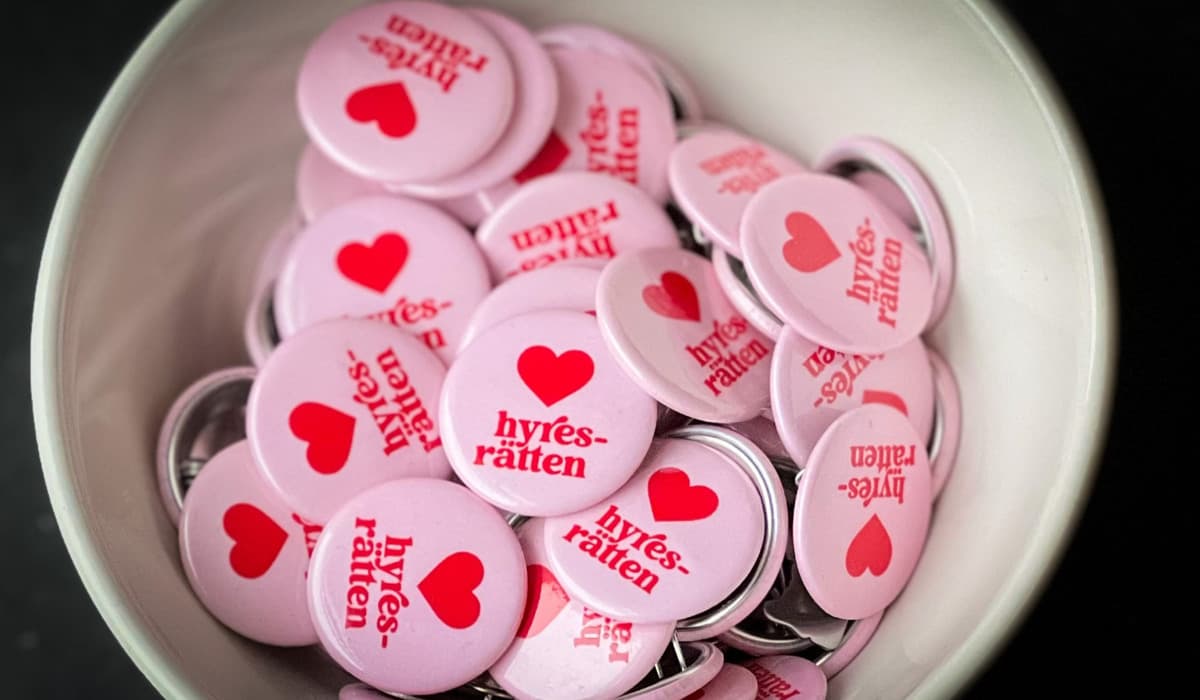 Vit skål full med rosa pins som har rött hjärta och texten "hyresrätten".