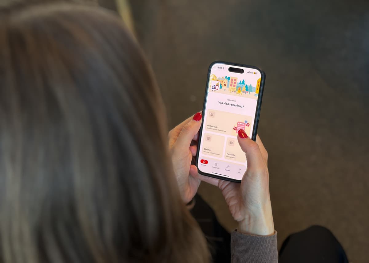 Person som håller i en mobiltelefon och scrollar i en app