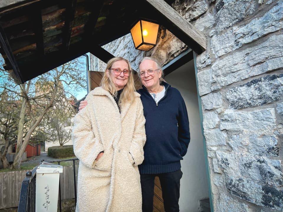 En kvinna och en man står på en trappa utanför hyreshuset Gamla Apoteket i Visby innerstad