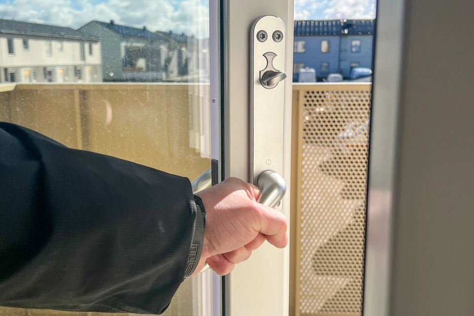 Hand som visar hur man låser och låser upp balkongdörr