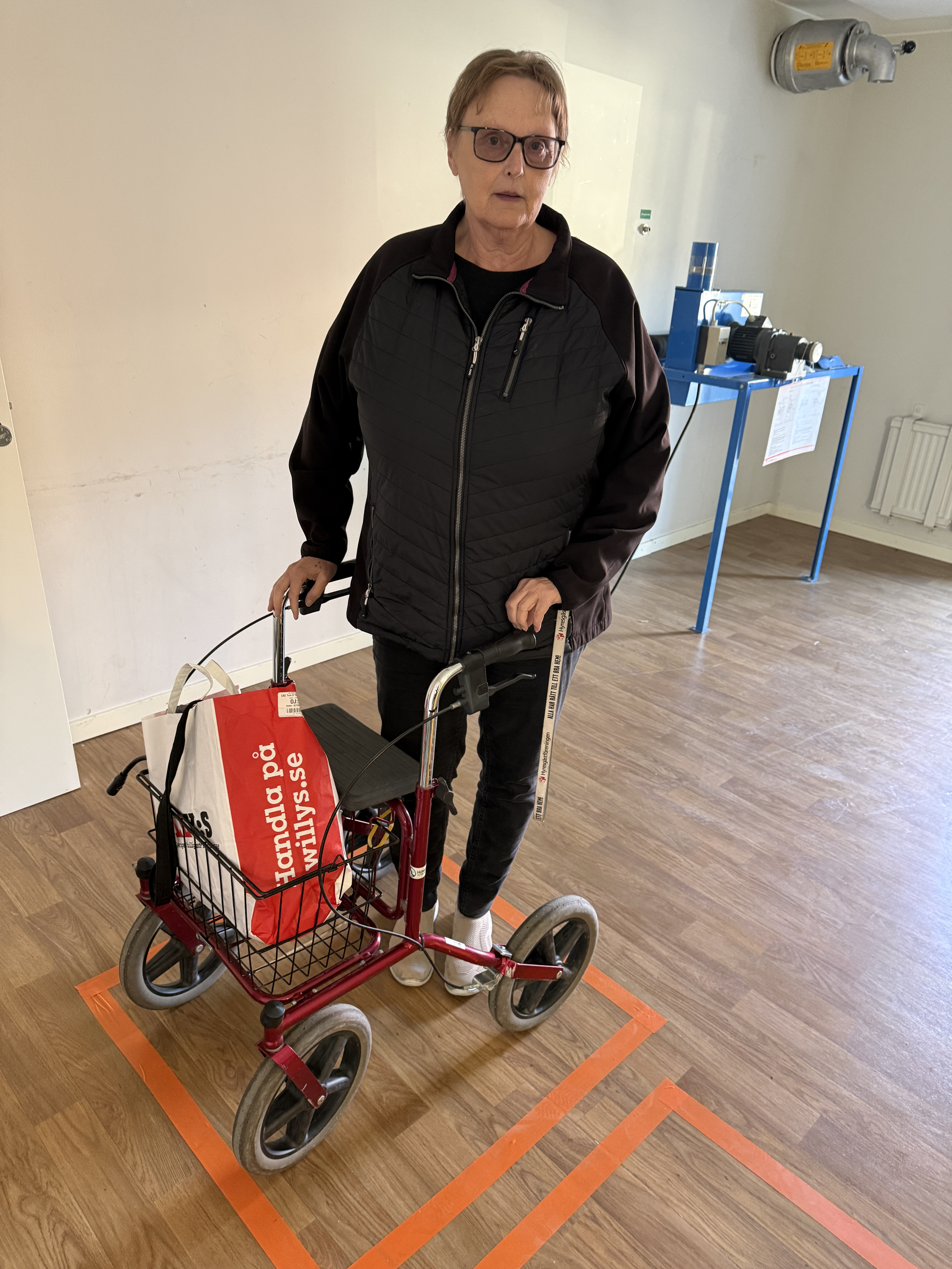 En kvinna med en rullator i ett rum.