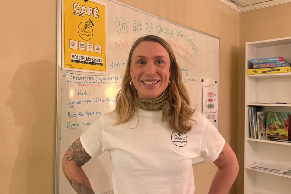 En kvinna står framför en whiteboard med skrift på.