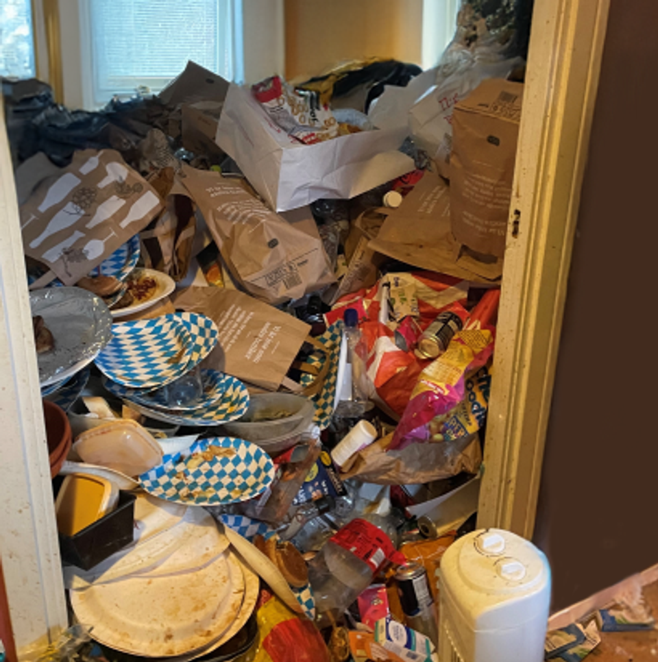 Ett rum fyllt med skräp. Det går inte att se golvet.