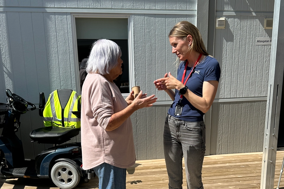 En medarbetare på Gotlandshem står och pratar med en hyresgäst. 