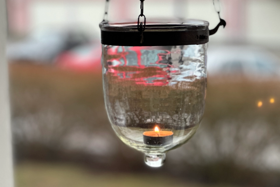 En ljuslykta med värmeljus i ett fönster.