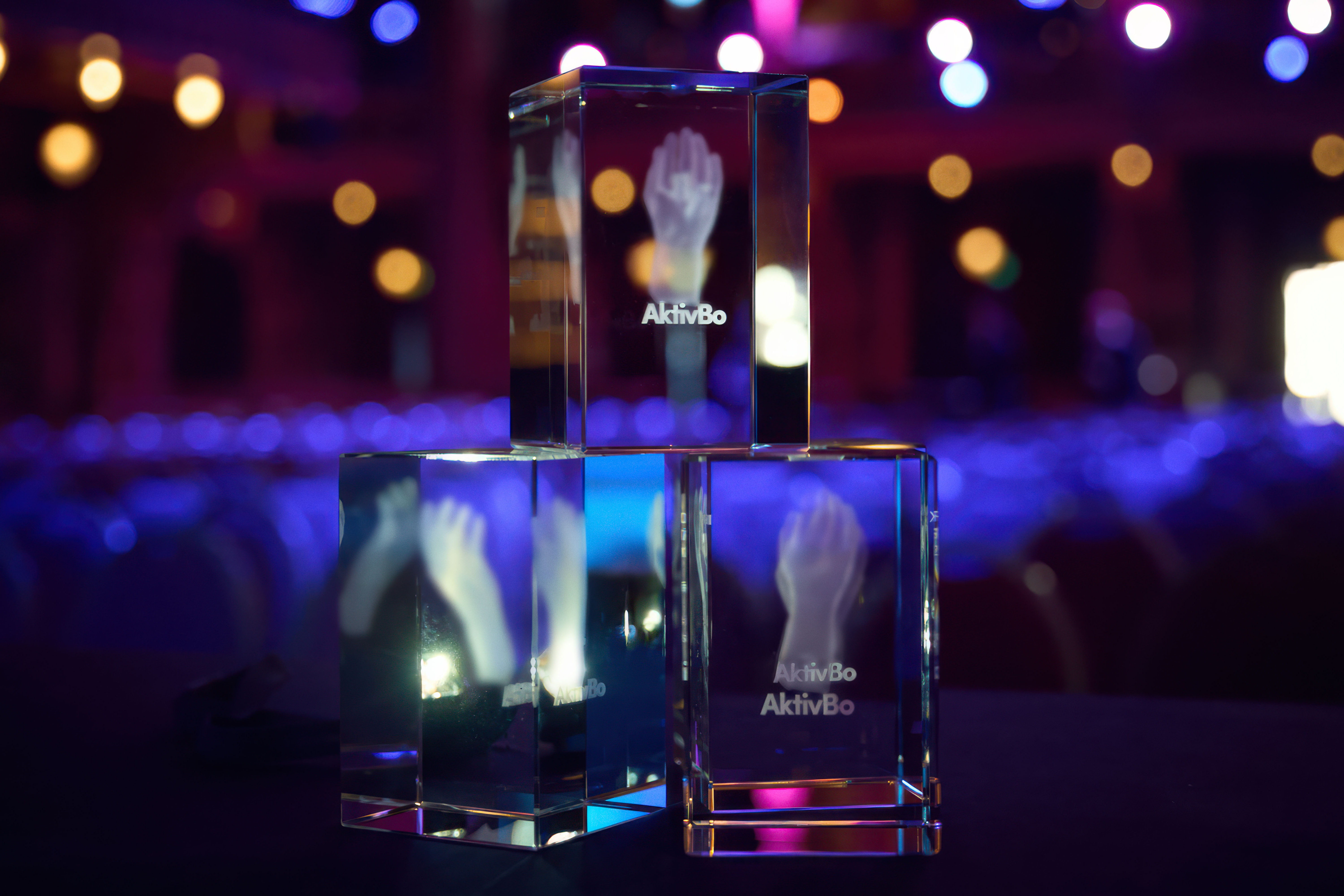 Några utmärkelsepriser i glas som står på ett bord.