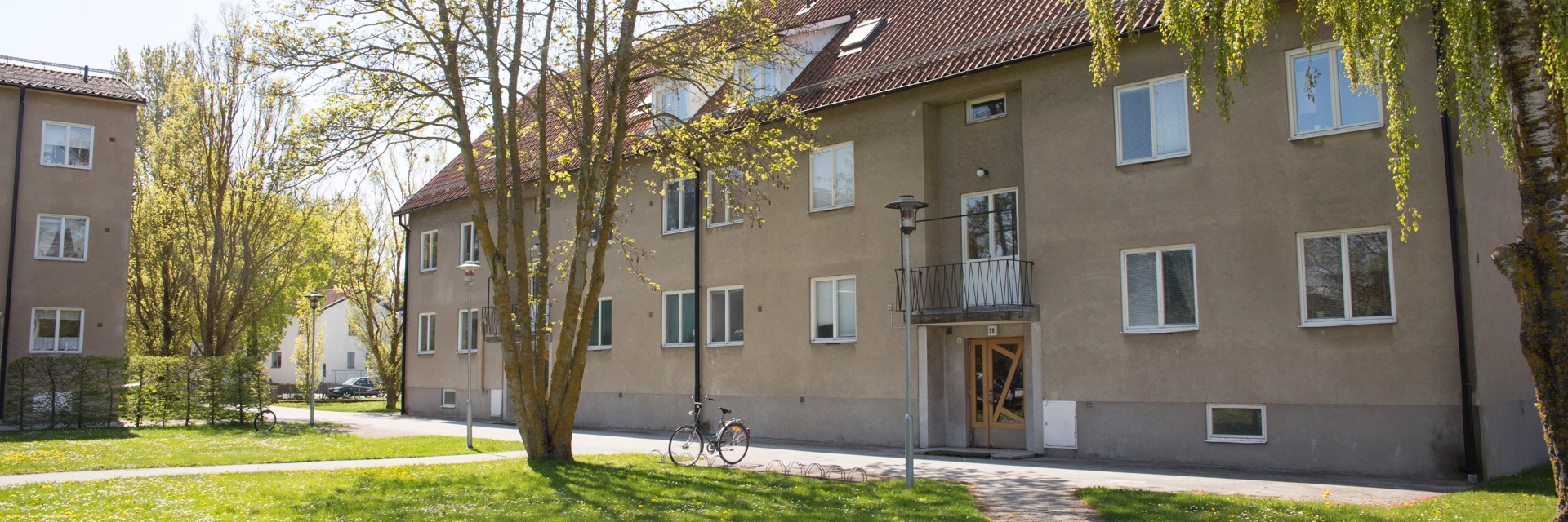 Beiget bostadshus med tegeltak på storgatan i Slite. Framför huset är det gräsmatta och ett trä.