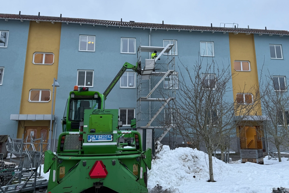 En husfasad och en grön skylift.