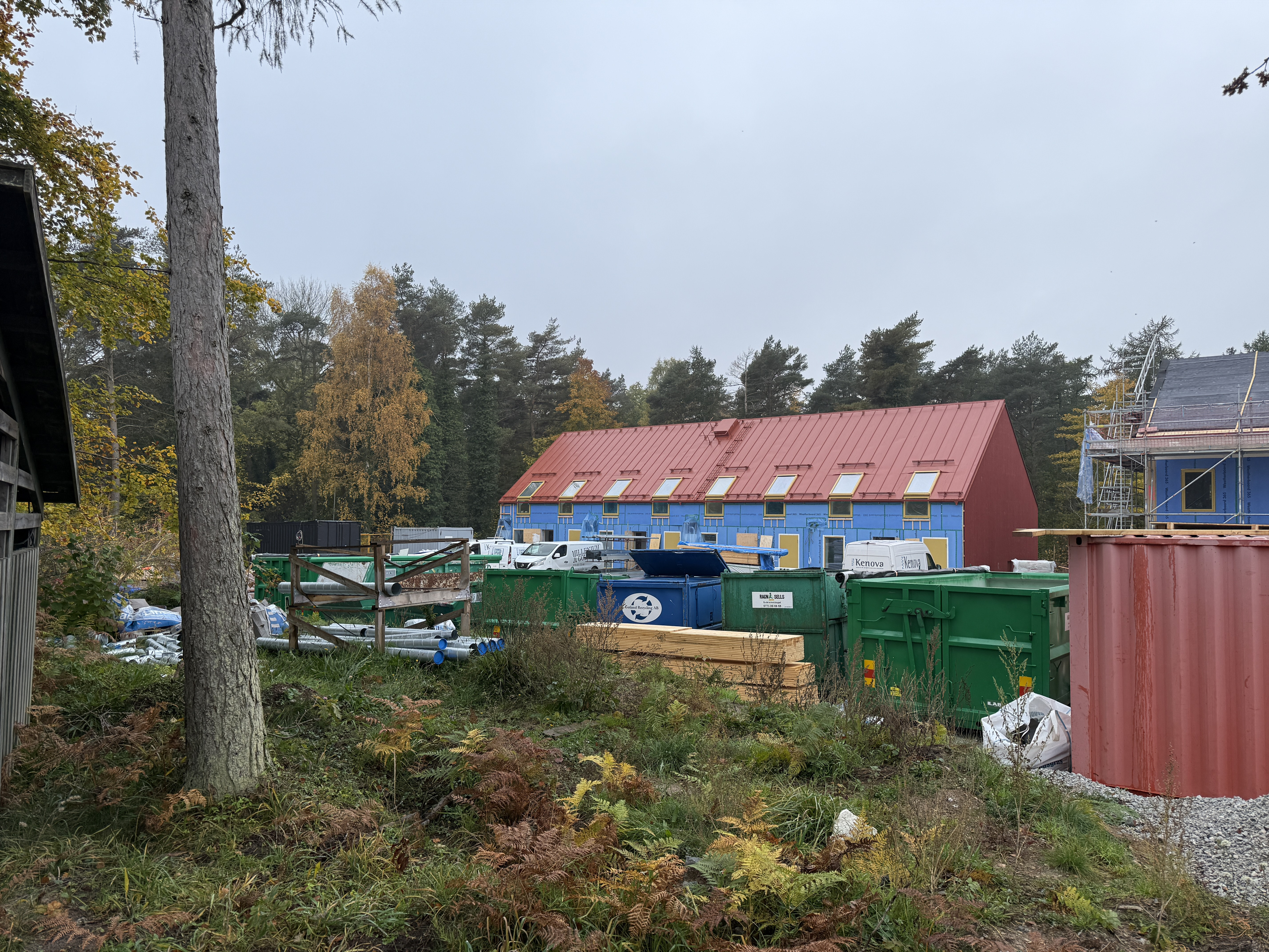 En grupp byggnader som ligger bredvid varandra. Ett nybyggt hus som nästan är klart syns på håll.