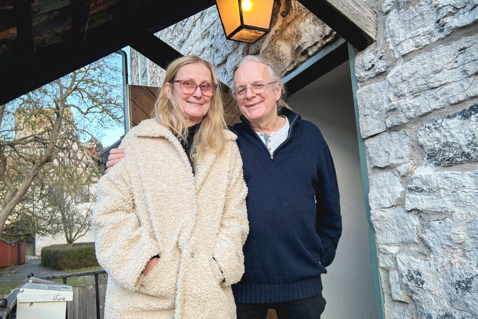 En kvinna och en man står på en trappa utanför hyreshuset Gamla Apoteket i Visby innerstad