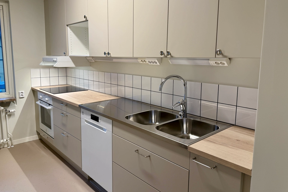 Ett nyrenoverat kök med beigea lådfronter och köksluckor. Ser ser färdigt ut att flytta in i. 