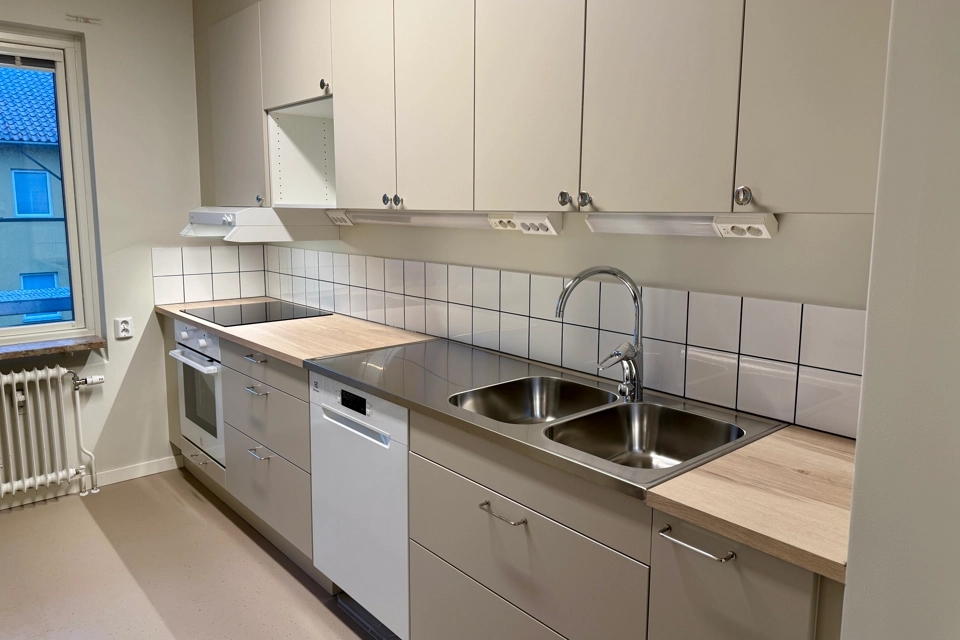 Ett nyrenoverat kök med beigea lådfronter och köksluckor. Ser ser färdigt ut att flytta in i. 