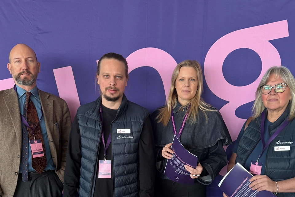 En grupp människor som står framför en fotovägg.