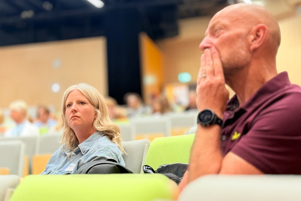 En man och en kvinna sitter i en aula.