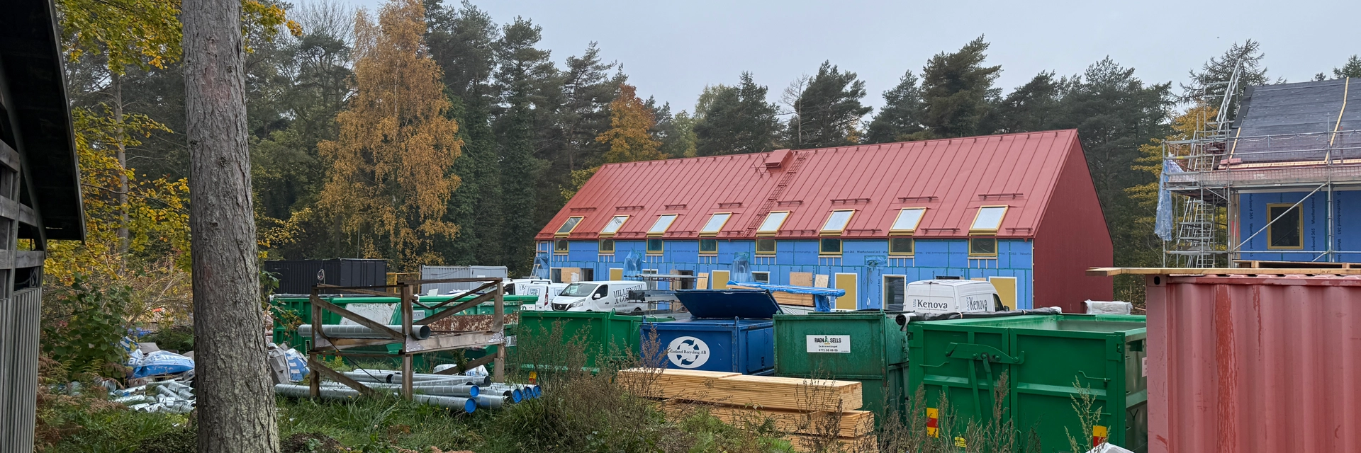 En grupp byggnader som ligger bredvid varandra. Ett nybyggt hus som nästan är klart syns på håll.