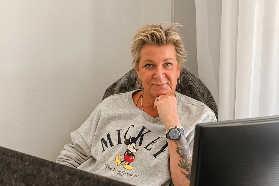 En kvinna som sitter i en stol med en bärbar dator.