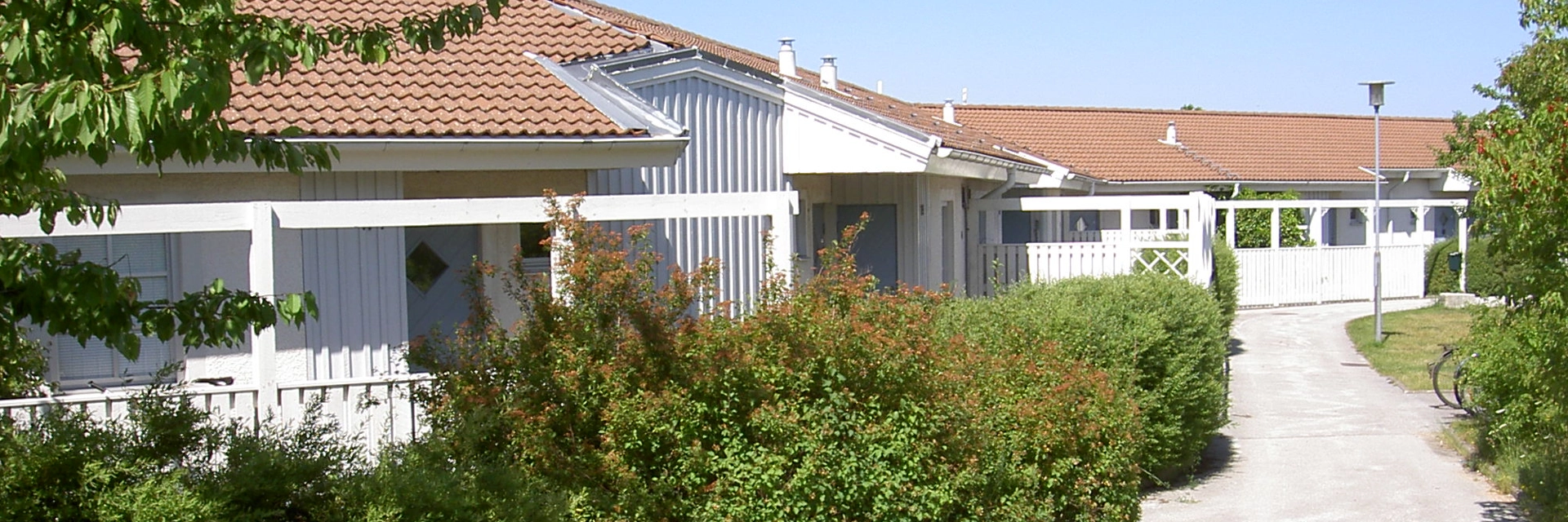 Vita trähus och grönska.