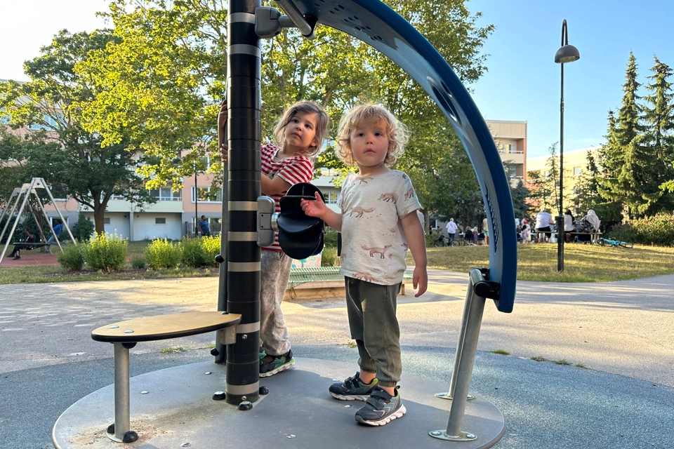 Några barn som står bredvid varandra på en lekplats.