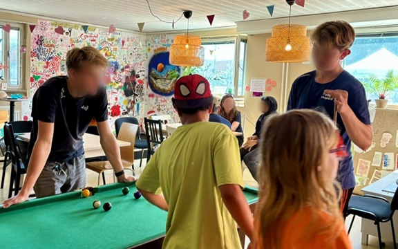 En grupp barn som spelar biljard.