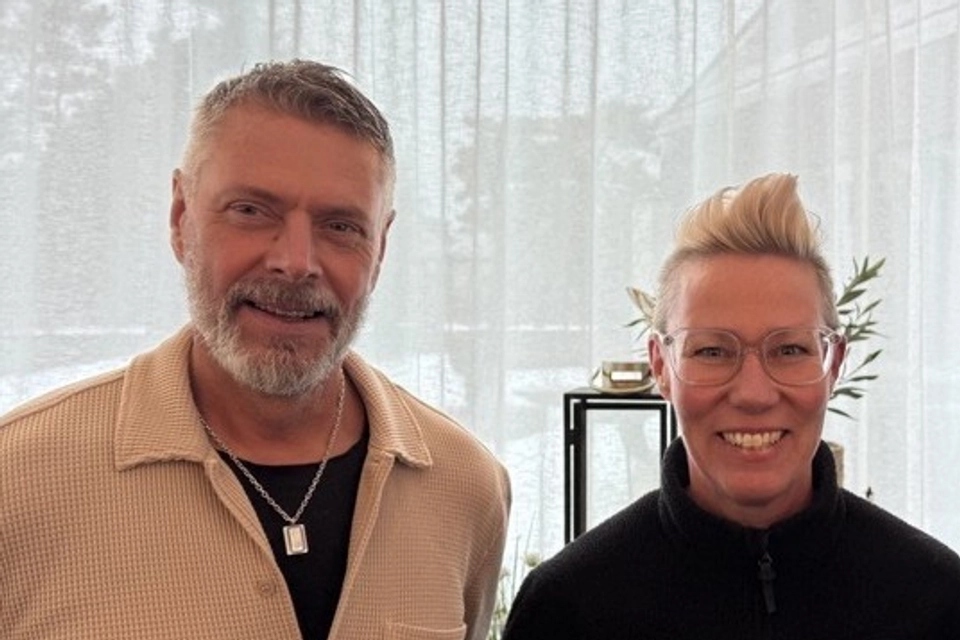 En man och en kvinna ser in i kameran och ler.